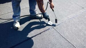 Homeowner inspecting roof shingles and clean gutters from the ground beside a two-story house