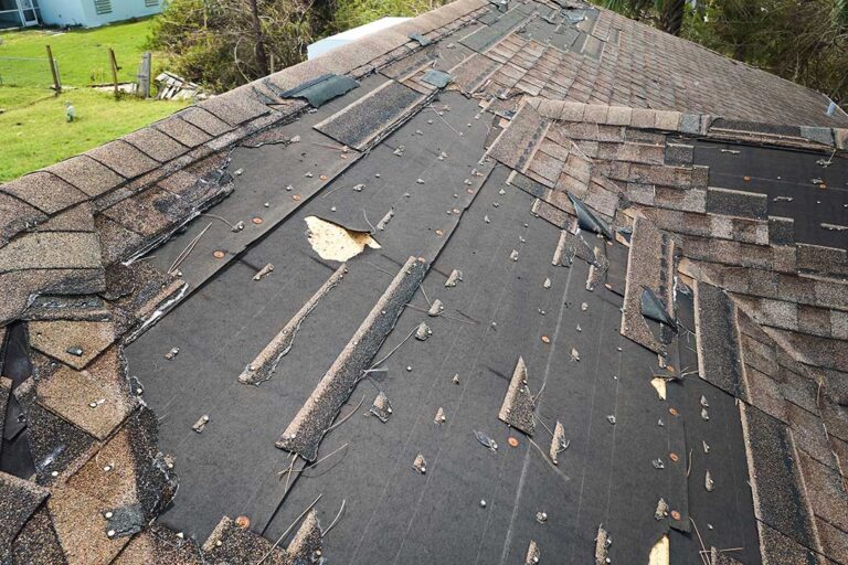 Roofing samples with rating labels, reflectance charts, and a hand comparing shingle surfaces on a workbench