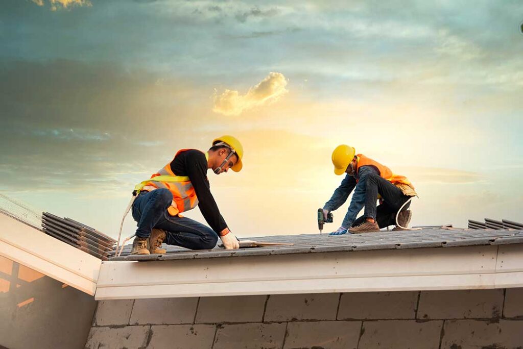 Roofing workers inspect clean attic insulation beneath a newly installed roof during a bright daytime repair.