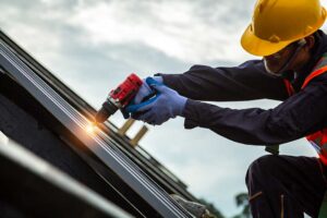 Roofing workers inspect attic insulation and ventilation beneath a newly replaced residential roof.