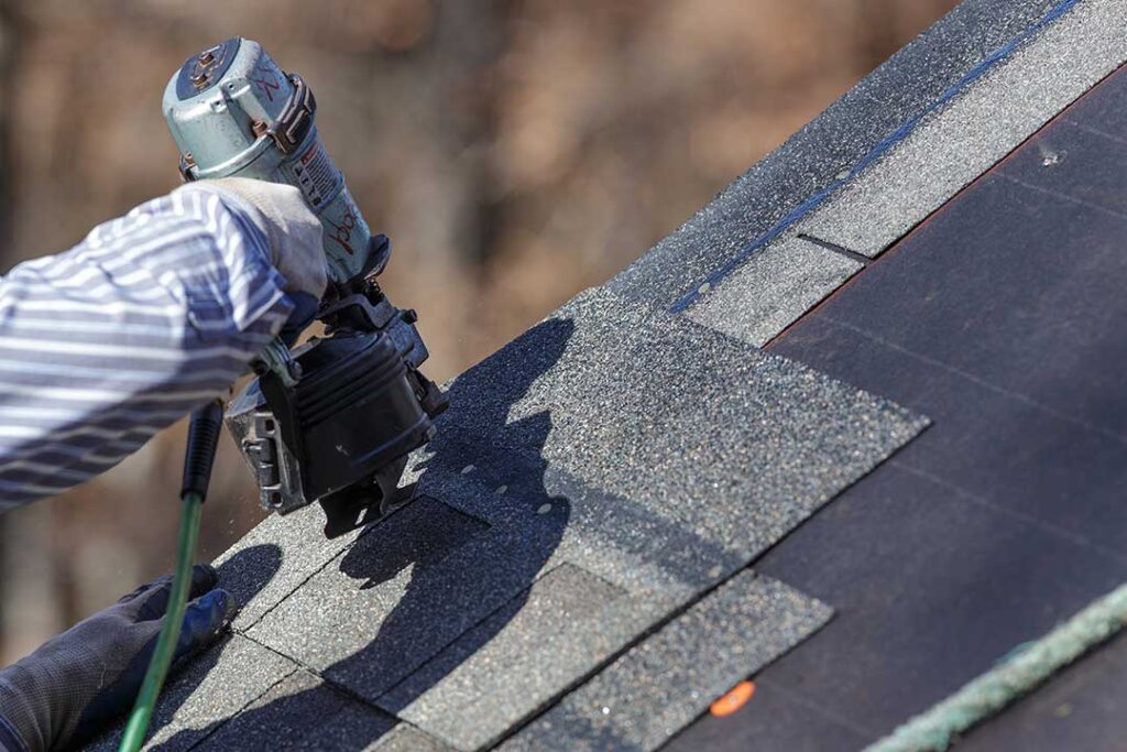 Homeowner reviews a detailed roofing proposal with a contractor beside a house roof and inspection materials.