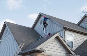 Homeowner checks gutters and roof edges from the ground before leaving for vacation.