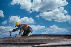 A homeowner measures roof slope with a level and tape measure beside attic rafters.