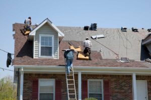 Homeowner reviews a roofing contract beside a ladder, sample materials, and storm-damaged shingles.