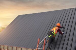 A homeowner examines a ceiling water stain while roof flashing and shingles are visible through an attic opening.